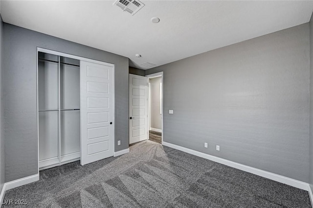 unfurnished bedroom featuring baseboards, visible vents, carpet, and a closet