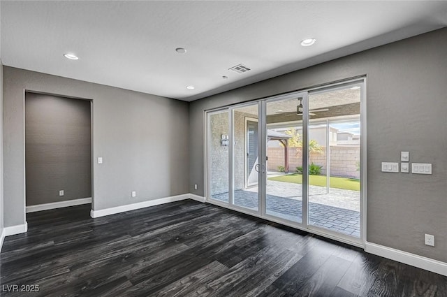 empty room with recessed lighting, baseboards, visible vents, and dark wood-type flooring