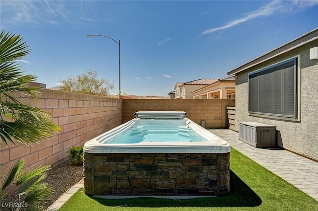 view of pool featuring fence and a covered hot tub