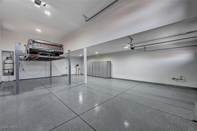 garage with baseboards and a garage door opener