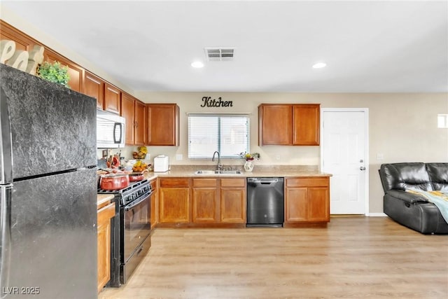 4195 Story Rock St, Las Vegas, NV 89115 - kitchen featuring a sink, open floor plan, light wood-type flooring, visible vents, and black appliances