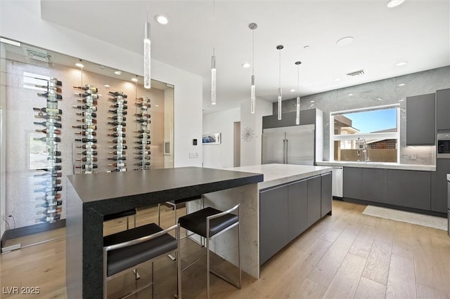 kitchen featuring built in refrigerator, modern cabinets, gray cabinetry, and a spacious island