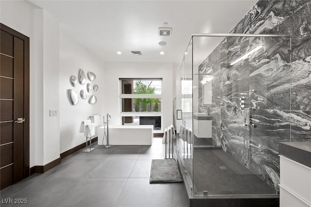 full bathroom featuring a freestanding tub, vanity, a marble finish shower, and visible vents