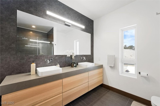 bathroom featuring a stall shower, tile patterned floors, a sink, and tasteful backsplash