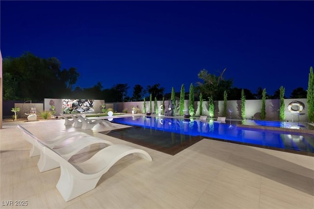 pool at night with a fenced in pool, fence private yard, and a patio