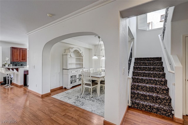 10519 Bella Camrosa Dr, Las Vegas, NV 89141 - interior space featuring crown molding, arched walkways, stairway, baseboards, and light wood finished floors