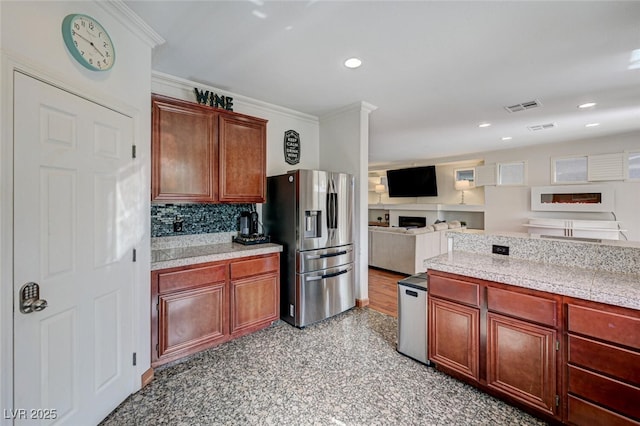 10519 Bella Camrosa Dr, Las Vegas, NV 89141 - kitchen featuring decorative backsplash, visible vents, a fireplace, stainless steel fridge with ice dispenser, and ornamental molding