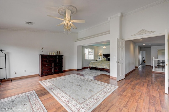 10519 Bella Camrosa Dr, Las Vegas, NV 89141 - bedroom with a ceiling fan, baseboards, wood finished floors, visible vents, and ornamental molding