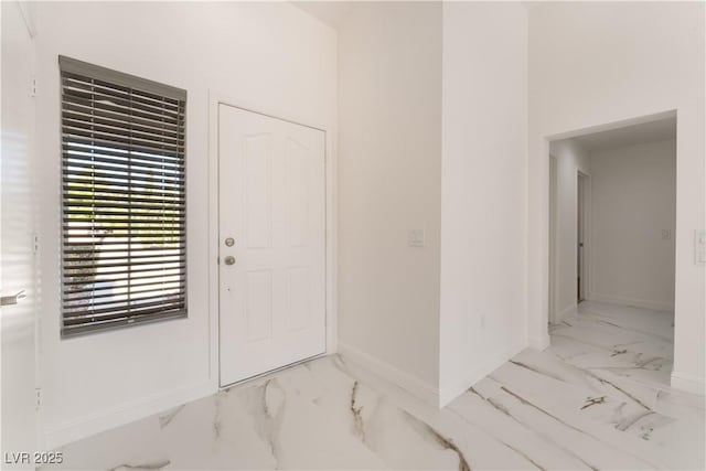 foyer entrance featuring baseboards and marble finish floor