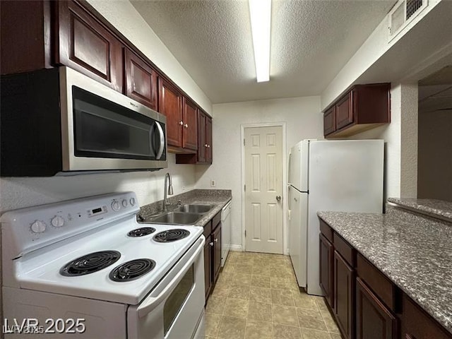kitchen with dark brown cabinets, a sink, white appliances, a textured ceiling, and visible vents