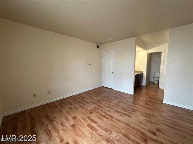 empty room featuring baseboards, visible vents, and wood finished floors