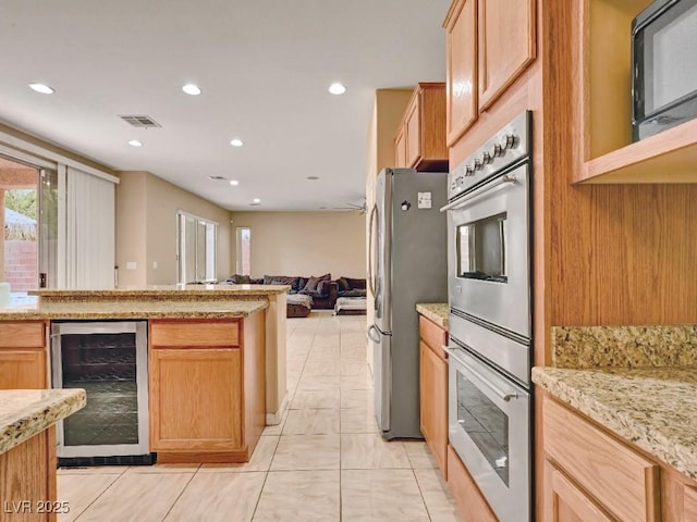 kitchen featuring beverage cooler, plenty of natural light, appliances with stainless steel finishes, and visible vents