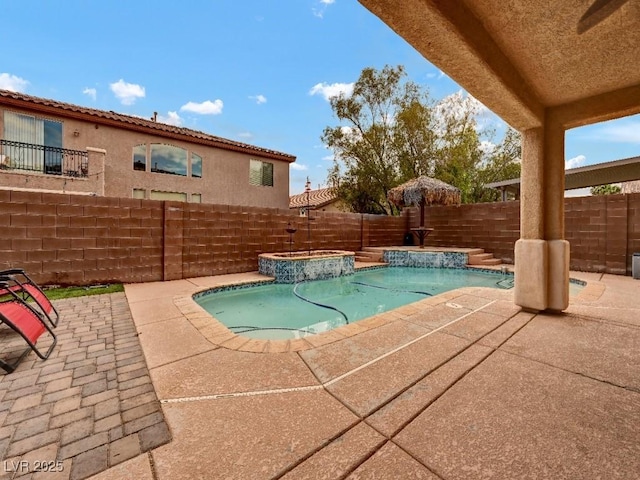 view of pool with a fenced backyard, a fenced in pool, a patio, and an in ground hot tub