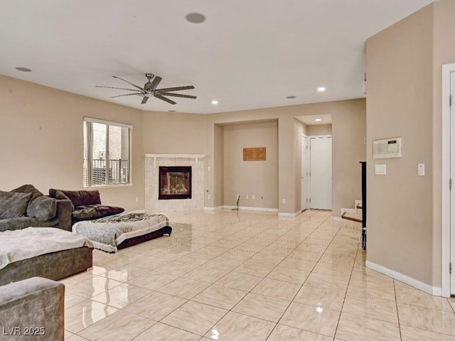 living area with a ceiling fan, a tile fireplace, light tile patterned floors, baseboards, and recessed lighting