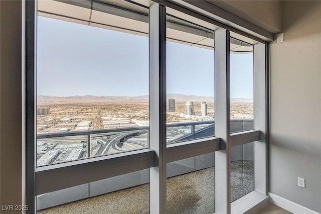 doorway with baseboards and a mountain view