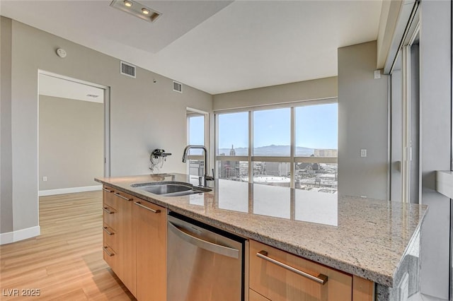 kitchen with a sink, light wood finished floors, dishwasher, visible vents, and modern cabinets
