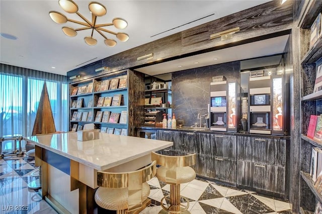 bar with a sink, light tile patterned floors, and a notable chandelier