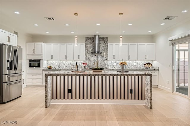 2372 Perrysburg Dr, Henderson, NV 89044 - kitchen with stainless steel appliances, wall chimney exhaust hood, backsplash, an island with sink, and white cabinets