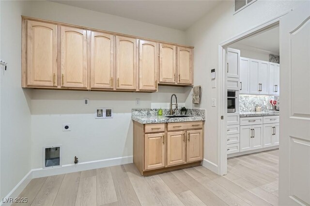2372 Perrysburg Dr, Henderson, NV 89044 - laundry room with hookup for a gas dryer, cabinet space, hookup for an electric dryer, washer hookup, and light wood-type flooring