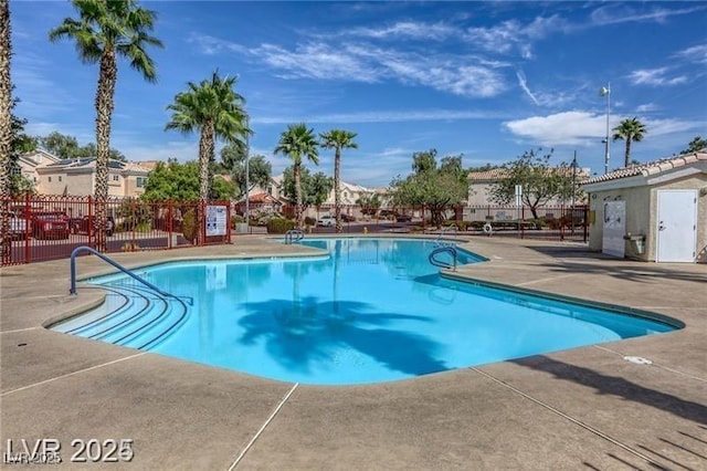 community pool featuring fence and a patio