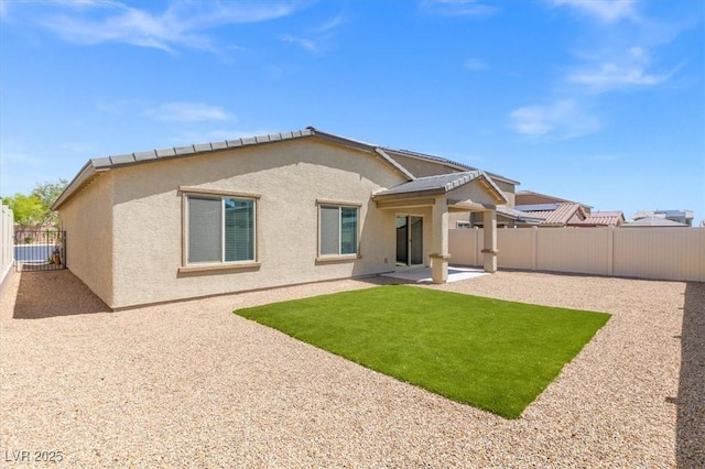 13 Deseo Ct, North Las Vegas, NV 89031 - back of property featuring a fenced backyard, stucco siding, a yard, and a patio area