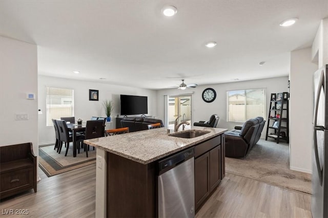 13 Deseo Ct, North Las Vegas, NV 89031 - kitchen featuring stainless steel appliances, open floor plan, a sink, and light wood finished floors