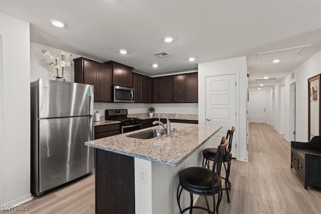 13 Deseo Ct, North Las Vegas, NV 89031 - kitchen featuring visible vents, dark brown cabinetry, a sink, light wood-style flooring, and appliances with stainless steel finishes