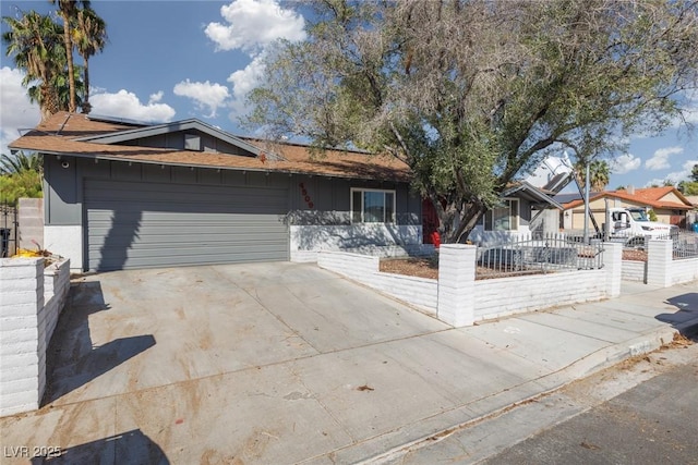 ranch-style house featuring concrete driveway, an attached garage, a fenced front yard, and solar panels