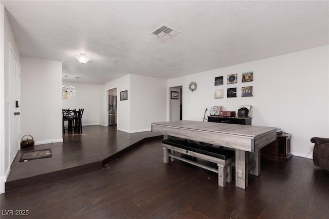 dining space with baseboards, a notable chandelier, wood finished floors, and visible vents