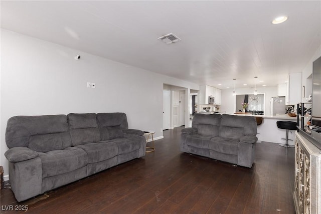 living area featuring visible vents and dark wood-style floors