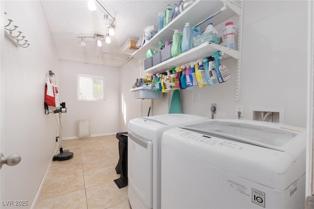 washroom featuring laundry area, a textured ceiling, light tile patterned floors, baseboards, and washer and dryer