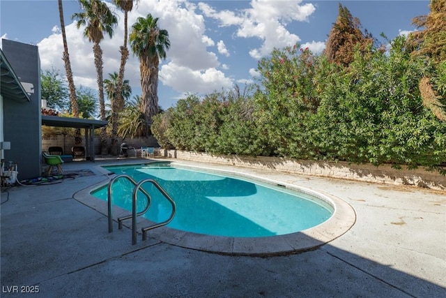 outdoor pool with a patio area and fence