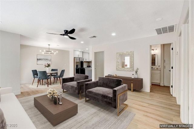 living room featuring recessed lighting, light wood-style flooring, and visible vents