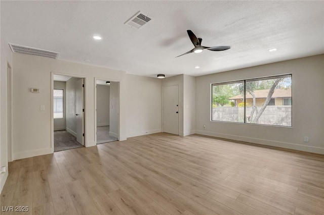 interior space with baseboards, ceiling fan, light wood-type flooring, and visible vents