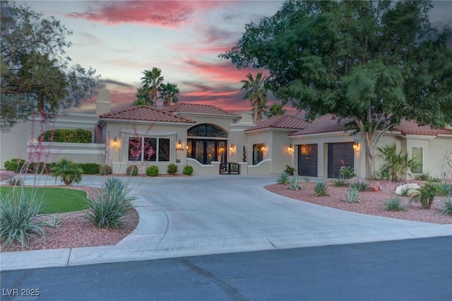 4594 Blue Mesa Way, Las Vegas, NV 89129 - mediterranean / spanish home featuring a tile roof, an attached garage, driveway, and stucco siding