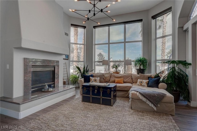 4594 Blue Mesa Way, Las Vegas, NV 89129 - living room with a high end fireplace, a high ceiling, wood finished floors, and a chandelier