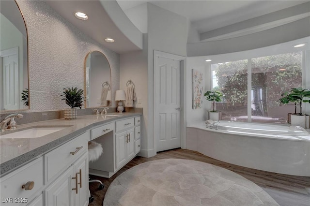 4594 Blue Mesa Way, Las Vegas, NV 89129 - bathroom featuring a sink, a garden tub, double vanity, and wood finished floors