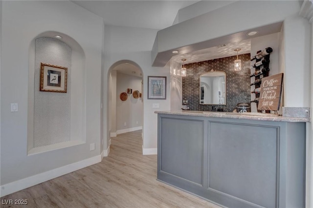 4594 Blue Mesa Way, Las Vegas, NV 89129 - interior space with arched walkways, baseboards, bar, and wood finished floors