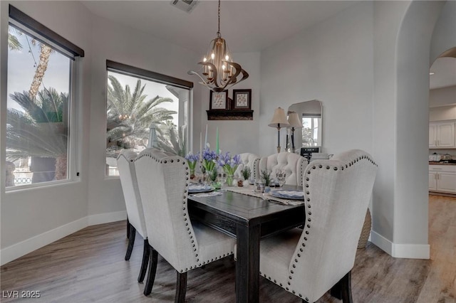 4594 Blue Mesa Way, Las Vegas, NV 89129 - dining space featuring a notable chandelier, arched walkways, baseboards, light wood-type flooring, and visible vents