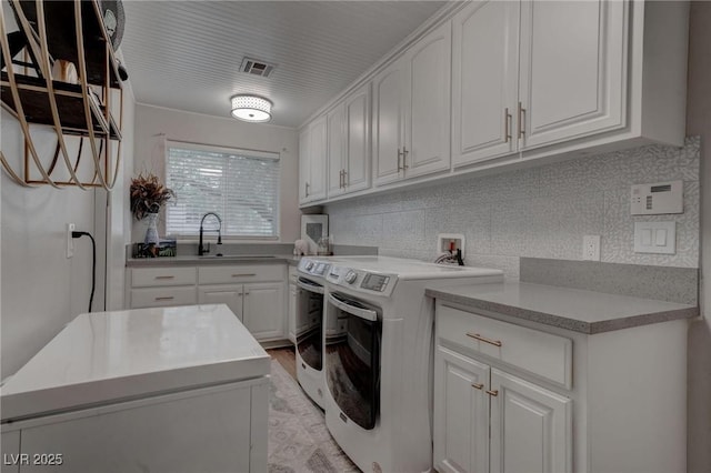 4594 Blue Mesa Way, Las Vegas, NV 89129 - laundry area with visible vents, cabinet space, a sink, light wood finished floors, and separate washer and dryer