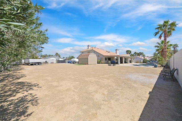 view of yard featuring fence and a storage shed