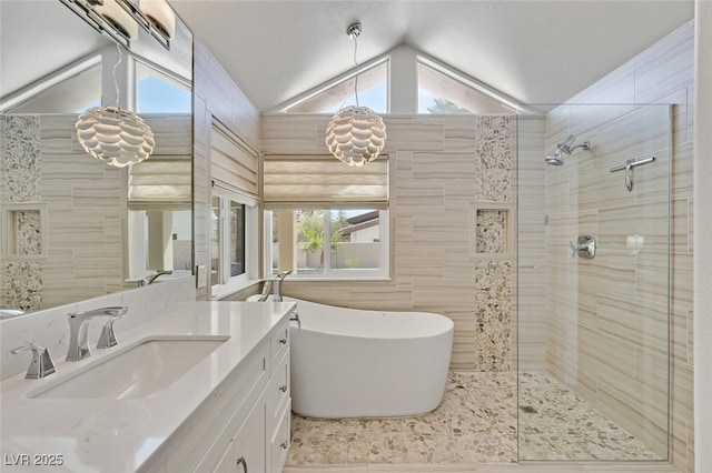 full bath featuring plenty of natural light, vaulted ceiling, vanity, a soaking tub, and tiled shower
