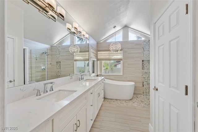 full bathroom featuring a sink, a freestanding tub, lofted ceiling, and a tile shower