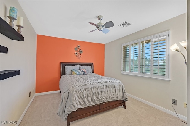 carpeted bedroom with visible vents, a ceiling fan, and baseboards