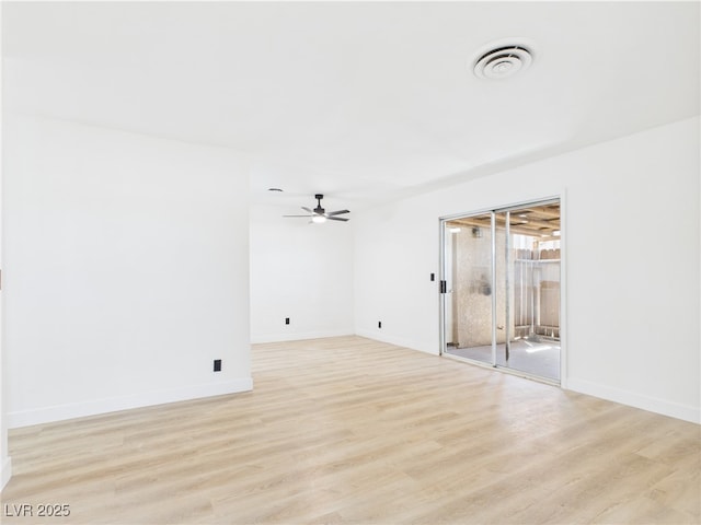 empty room featuring visible vents, light wood finished floors, ceiling fan, and baseboards