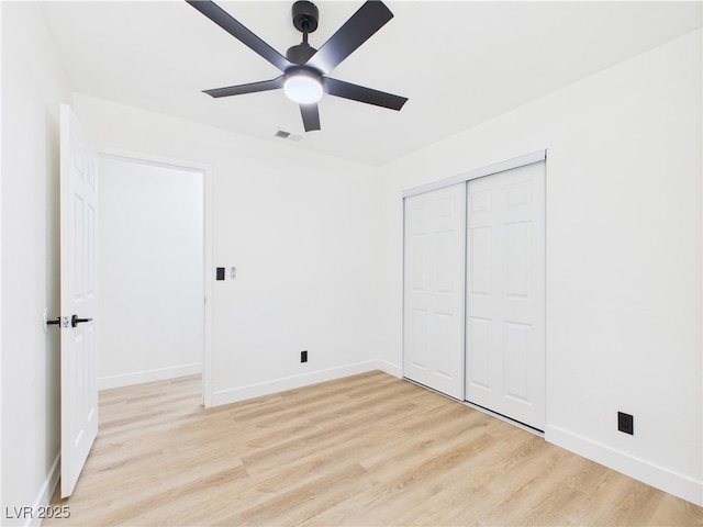 unfurnished bedroom with visible vents, light wood-style flooring, baseboards, and a closet