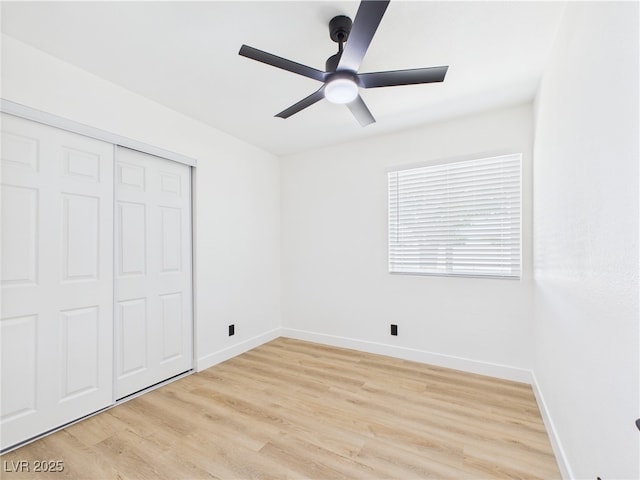 unfurnished bedroom with a closet, baseboards, ceiling fan, and light wood-type flooring