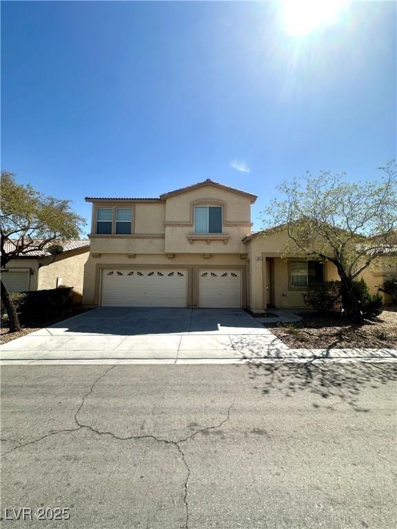 view of front of property with an attached garage, stucco siding, and driveway