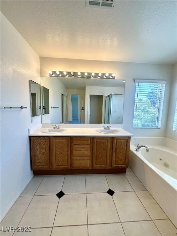 full bath with double vanity, visible vents, a tub with jets, and a sink