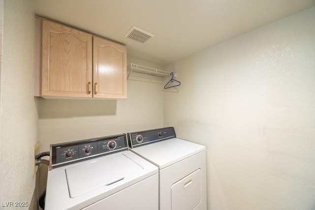 laundry room with visible vents, cabinet space, and washer and dryer